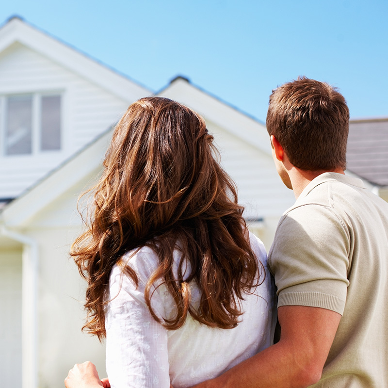 couple standing in front of their new house